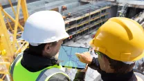 Construction workers on a construction site using a tablet